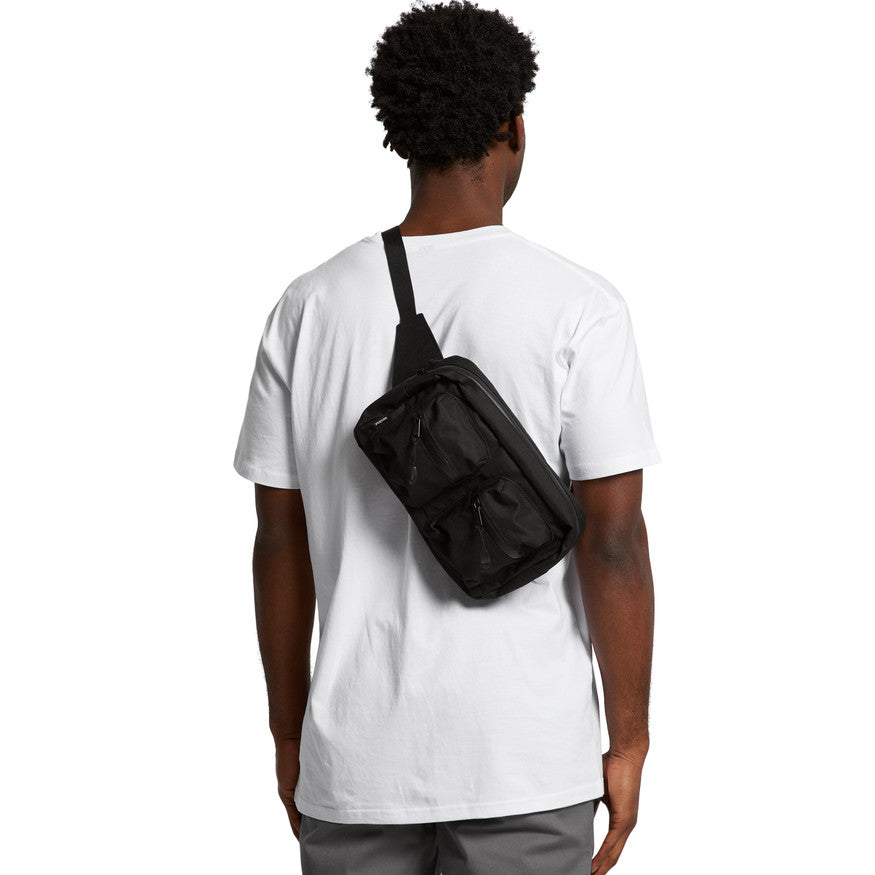 Person wearing a black crossbody bag on a white background