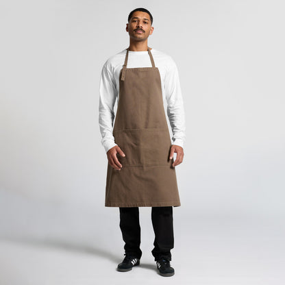 Male model wearing a professional brown bib apron over a blank t-shirt, a durable workwear option for Christchurch hospitality and retail businesses wanting custom embroidery.