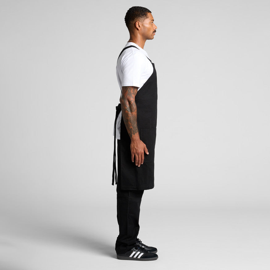 A person wearing a classic white blank t-shirt and durable black overalls, a practical workwear uniform combination suitable for custom Christchurch branding with embroidery or Supacolor transfers.