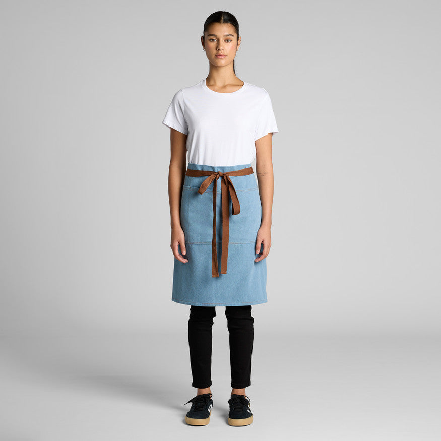 Person wearing a white shirt, black pants, and a blue apron with a brown belt on a gray background