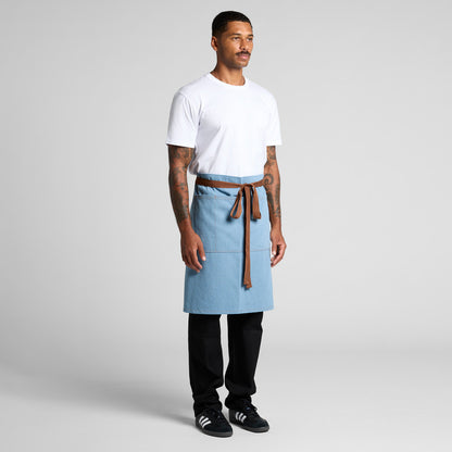 Man wearing a light blue apron with a brown belt on a gray background