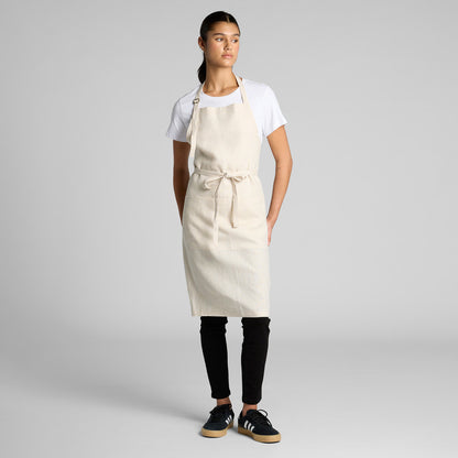 Person wearing a beige apron on a plain background