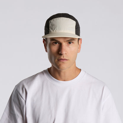 Man wearing a black and beige cap on a white background