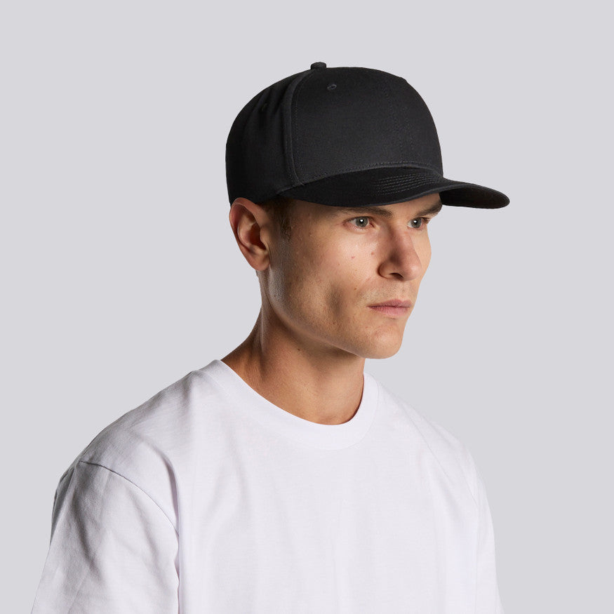 Man wearing a black cap and white t-shirt against a light gray background