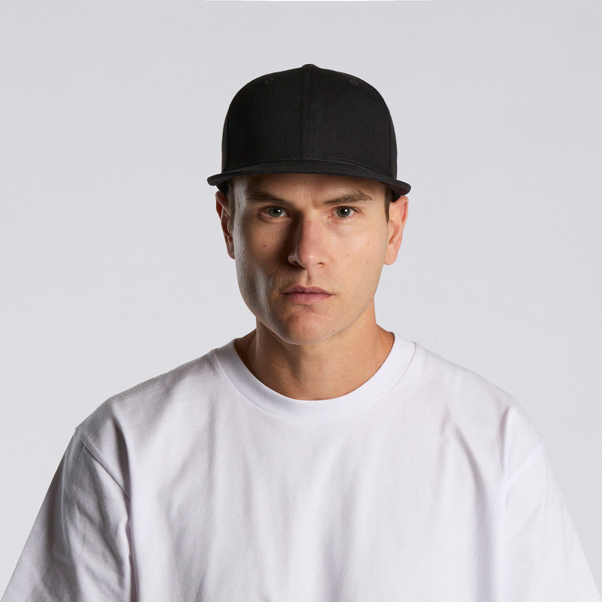 Man wearing a black cap and white t-shirt against a light gray background