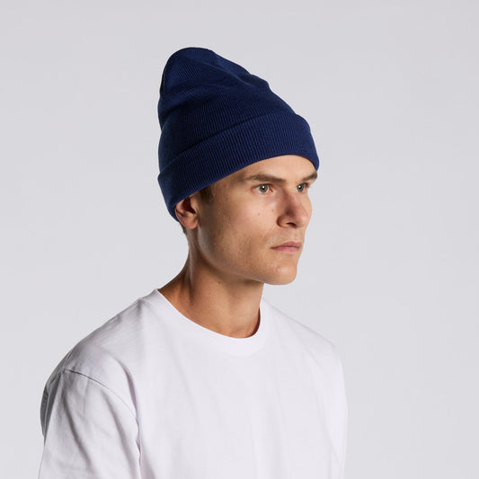 Man wearing a navy blue beanie and white shirt on a light gray background