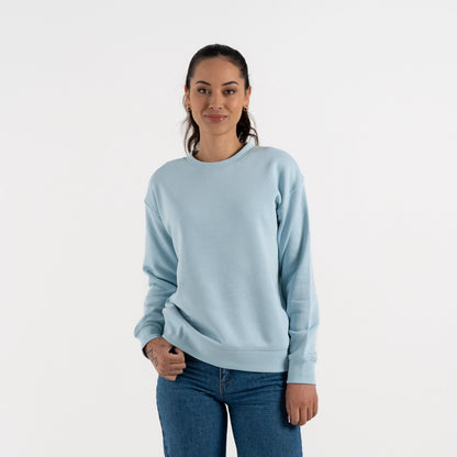 Woman wearing a light blue sweatshirt and jeans on a white background