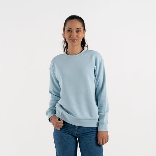 Woman wearing a light blue sweatshirt and jeans on a white background