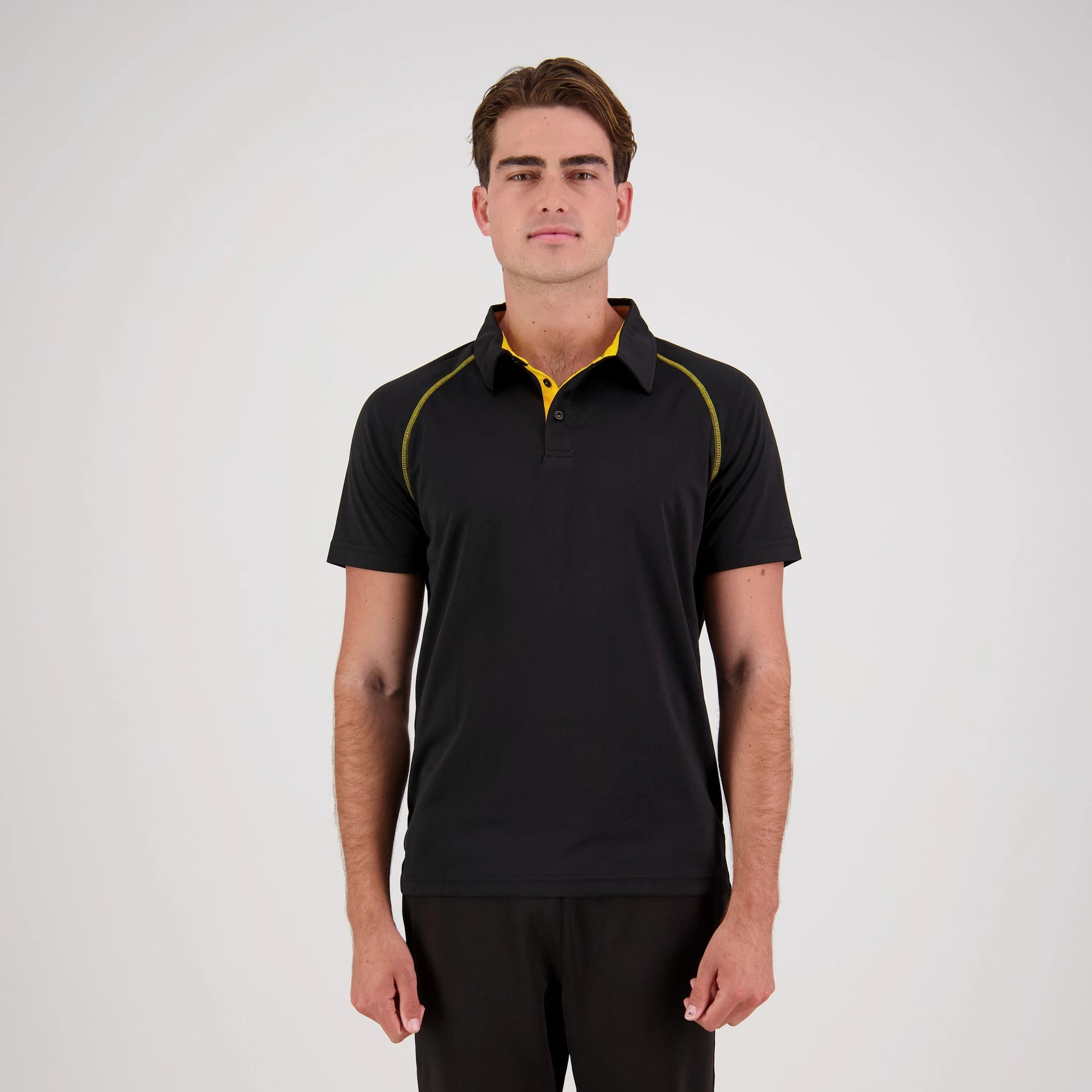 Man wearing a black polo shirt with yellow accents on a white background