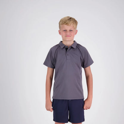 Young boy wearing a gray polo shirt and navy shorts on a white background