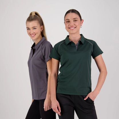 Two women wearing polo shirts against a plain background