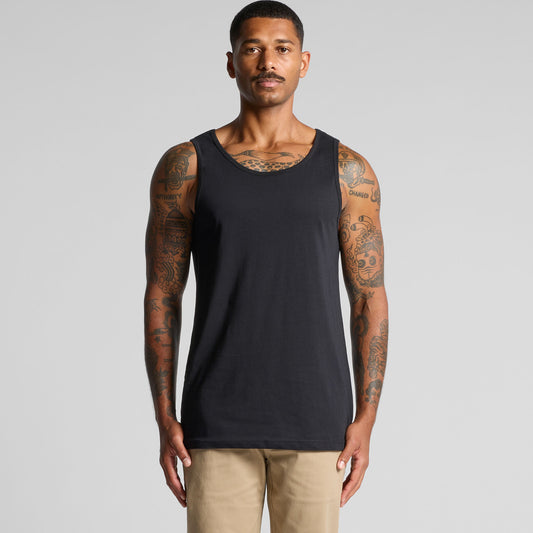 Man wearing a black tank top against a gray background